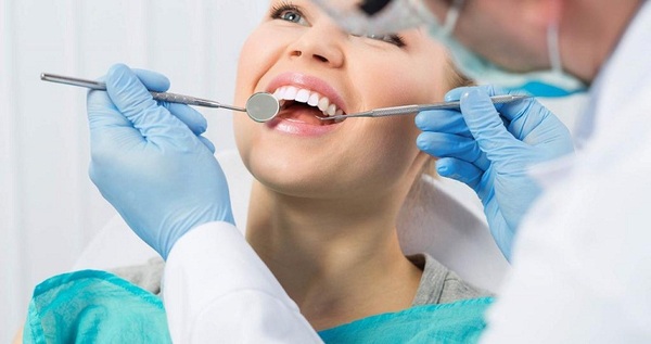 Bác sĩ kiểm tra sức khỏe răng miệng